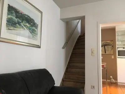 a living room with a couch and a staircase at Tongeren Schuttersgang 1 in Tongeren