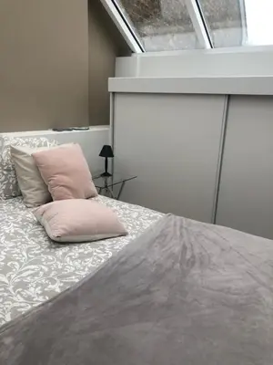a bedroom with a bed with a pink pillow on it at Tongeren Schuttersgang 1 in Tongeren