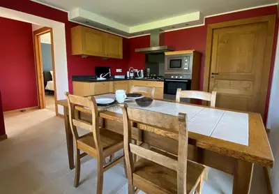 a kitchen with a large wooden table and chairs at En Vert & En Pause in Thimister