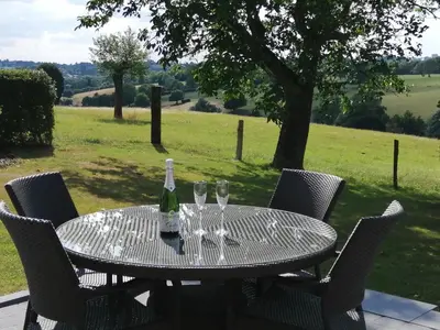 a table with wine glasses and a bottle on it at En Vert & En Pause in Thimister