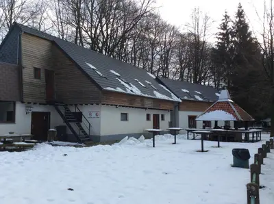 a building with snow on the roof and a picnic table at Dortoirs Le Domaine in Bilstain