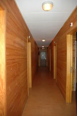 a hallway with wood paneled walls and a long corridor at Dortoirs Le Domaine in Bilstain