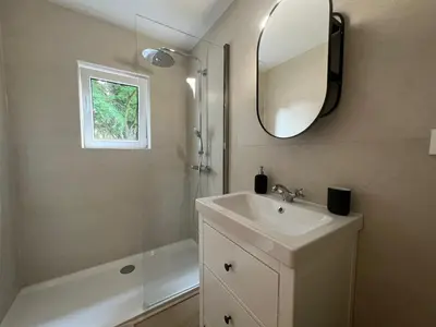 a bathroom with a sink and a mirror and a tub at Maison Léon in Bilstain