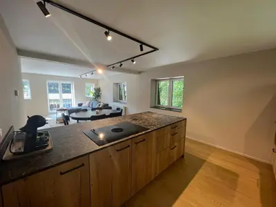 a kitchen with a counter top and a living room at Maison Léon in Bilstain