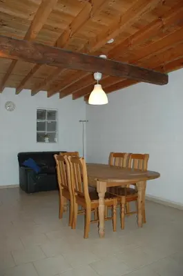 a dining room with a wooden table and chairs at Le Domaine Appartements in Bilstain