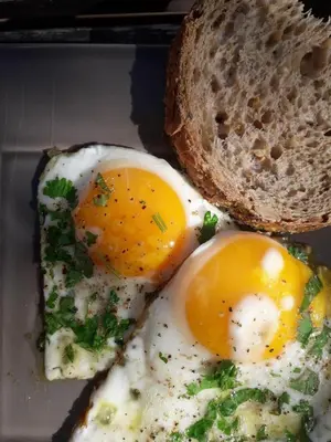 two eggs and a slice of bread on a plate at Maas&Mechelen B&B Massage & Wellness in Maasmechelen