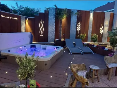 a jacuzzi tub on a patio with two chairs at La Renaissance - Deux gites de standing in Herve