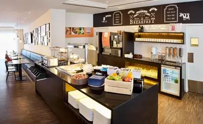 a restaurant with a counter with food on it at Holiday Inn Express Hasselt by IHG in Hasselt