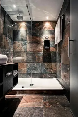 a bathroom with a large shower with a tub at M Hotel in Genk