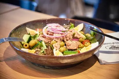 a bowl of food with meat and vegetables on a table at Holiday Inn Hasselt by IHG in Hasselt