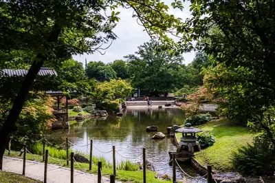 a pond in a park with people walking around it at Holiday Inn Hasselt by IHG in Hasselt