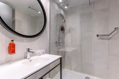 a bathroom with a sink and a shower with a mirror at Holiday Inn Hasselt by IHG in Hasselt