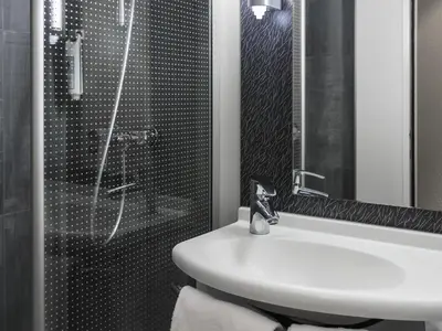 a bathroom with a white sink and a shower at ibis Liège Centre Opéra in Liège