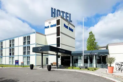 a building with a sign in front of it at Globales Post Hotel & Wellness in Herstal