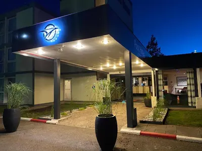a building with a sign in front of it at night at Globales Post Hotel & Wellness in Herstal