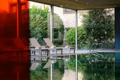 a group of chairs sitting next to a pool of water at Stiemerheide - The Urban Hotel & Golf Retreat 4 Star Superior in Genk