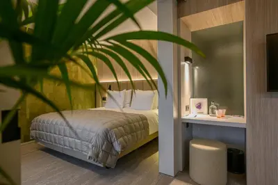 a bedroom with a bed and a plant at Stiemerheide - The Urban Hotel & Golf Retreat 4 Star Superior in Genk