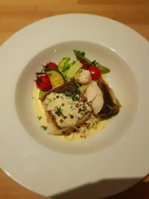 a white plate of food with meat and vegetables at Hotel Restaurant The Kings Head Inn in Voeren