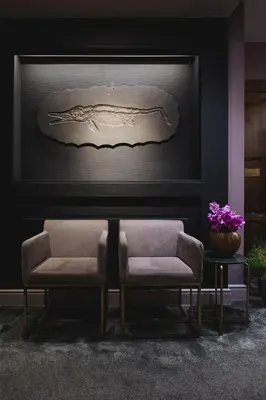 two chairs and a table in a room with a painting at La Butte aux Bois a Small Luxury Hotel of the World in Lanaken