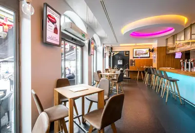 a restaurant with tables and chairs and a bar at Hotel The Century in Hasselt