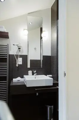 a bathroom with a sink and a mirror at Hotel The Century in Hasselt