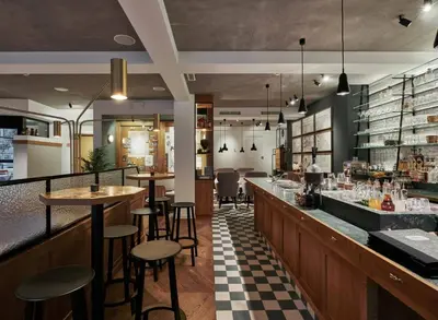 a restaurant with a bar with tables and stools at Green Hotel in Genk