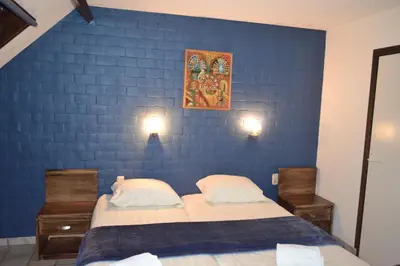 a bedroom with two beds and a blue wall at Hotel Plaza in Lommel