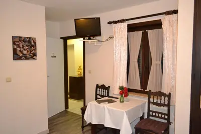 a dining room with a table and chairs and a television at Hotel Plaza in Lommel