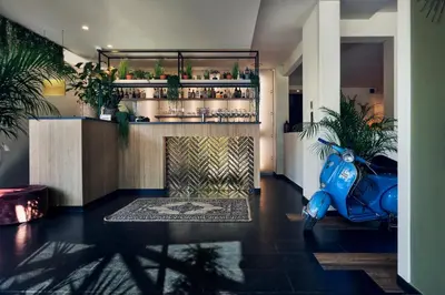 a blue scooter parked in a room with plants at Hotel Zuid in Genk