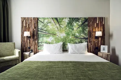 a bedroom with a large bed with a green blanket at Hotel Zuid in Genk