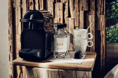a table with a blender and a bottle and a cup at Hotel Zuid in Genk