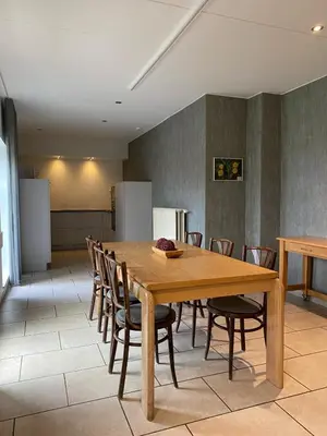 a dining room with a wooden table and chairs at d'Uyterwaerde in Leut