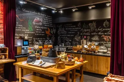 a restaurant with a table and a counter with food at pentahotel Liège in Liège