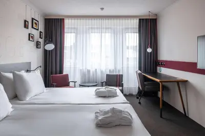 a hotel room with a bed and a desk at pentahotel Liège in Liège
