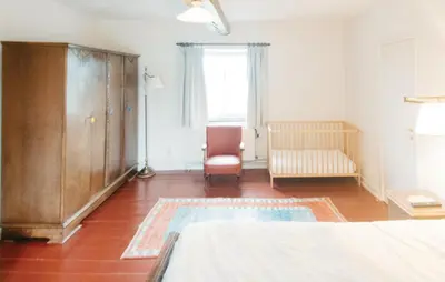 a bedroom with a bed and a chair and a window at Seven-Bedroom Holiday Home In Remersdaal in Remersdaal