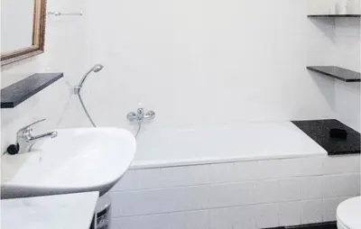 a white bathroom with a tub and a sink at Seven-Bedroom Holiday Home In Remersdaal in Remersdaal