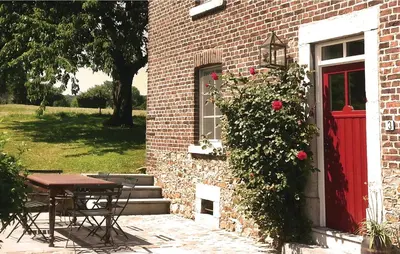 a brick building with a table and a red door at Seven-Bedroom Holiday Home In Remersdaal in Remersdaal