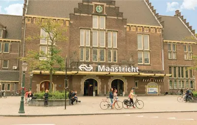 people riding bikes in front of a large brick building at Seven-Bedroom Holiday Home In Remersdaal in Remersdaal