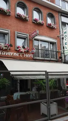 a restaurant with a white awning in front of a building at Hotel 'T Hert in Genk