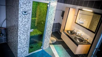 a bathroom with a shower with two sinks and a mirror at Sérénité - Espace Détente Ensival in Ensival