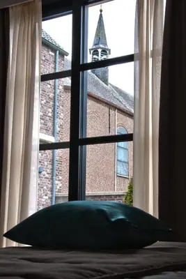 a pillow sitting on a bed in front of a window at Hotel Boomgaard in Lanaken