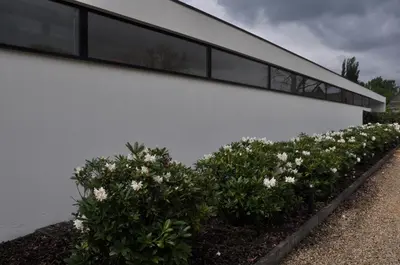 a white building with bushes in front of it at Hotel Boomgaard in Lanaken