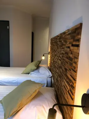 a bedroom with two beds and a brick wall at Hotel Le Cygne d'Argent in Liège