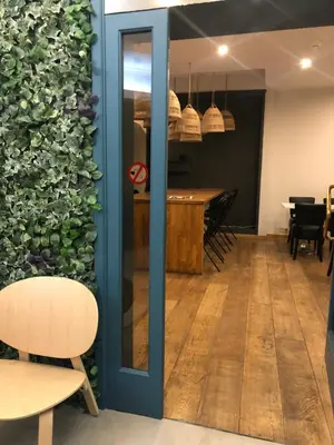 a room with a green wall with a table and chairs at Hotel Le Cygne d'Argent in Liège