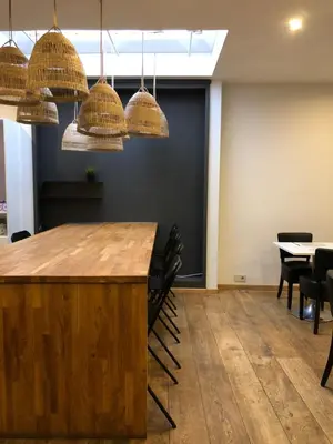 a conference room with a bar with chairs and chandeliers at Hotel Le Cygne d'Argent in Liège