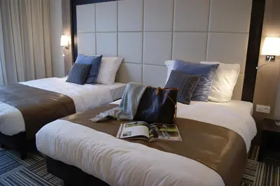 two beds in a hotel room with a book on them at Hotel Malpertuus in Riemst