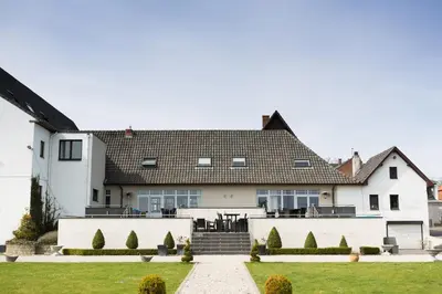 a white house with a black roof at Hotel Malpertuus in Riemst