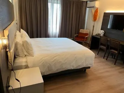 a hotel room with a white bed and a desk and a desk at Hotel Malpertuus in Riemst