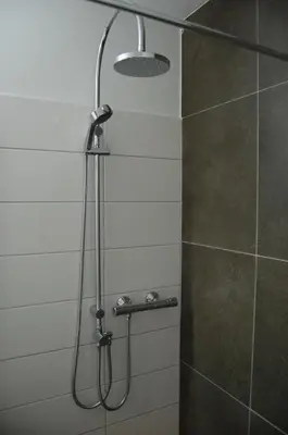 a shower with a shower head in a bathroom at Eurotel Lanaken in Lanaken