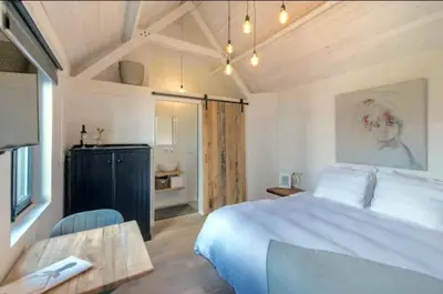 a bedroom with a large white bed and a table at Belle Chique - Maastricht in Lanaken
